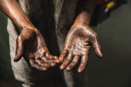 Close-up of a Black African American  male factory worker's greasy hands