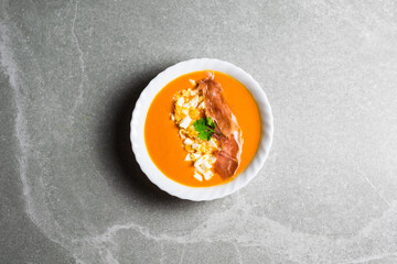 Plate of salmorejo with eggs and ham on a gray stone