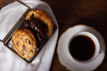 table set with cookies, milk jug and cup of coffee and book on the table