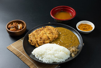 Tonkatsu Curry Rice (Japanese deep-fried pork cutlet with Curry rice) served with karaage (Japanese style fried chicken). on black background.