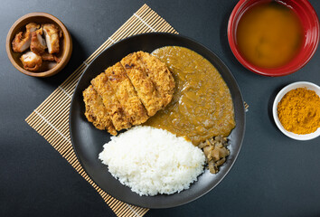 Tonkatsu Curry Rice (Japanese deep-fried pork cutlet with Curry rice) served with karaage (Japanese style fried chicken). top view on black background. flat lay.