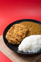 Tonkatsu Curry Rice (Japanese deep-fried pork cutlet with Curry rice). on red background. 