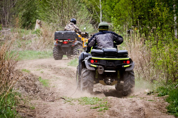Selective focus. Two riders on ATVs ride on a dirt road. The concept of outdoor activities and...