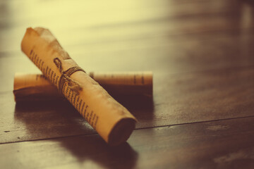 The vintage cafe with flower and medieval parchment roll of paper on wooden board