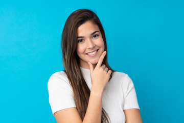 Teenager girl over isolated blue background smiling