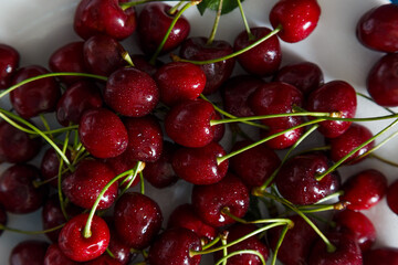 Fresh cherry on plate on wooden blue background.
