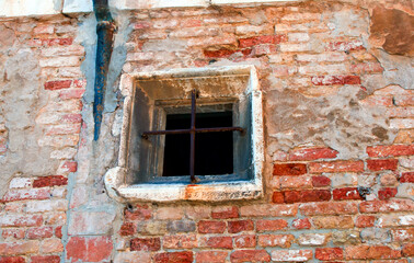 Fototapeta na wymiar window with rusty bars in a brick wall