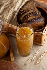 Homemade bread kvass. Summer carbonated soft drink. Glass and carafe on a wooden table. Black Overseas Rye Bread - Ingredients for a Drink. Copy space. Traditional cold rye drink Kvas in a jug.