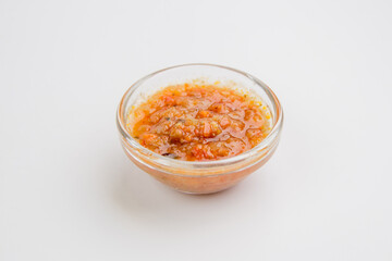 Adjika. Adjika sauce. Adjika in a sauceboat on a white background