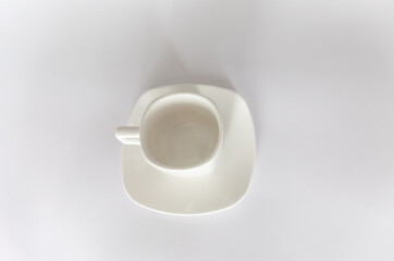 Empty white cup on saucer on white background