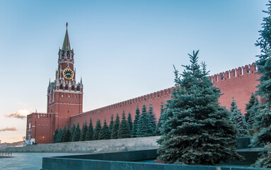 Fototapeta premium Spasskaya Tower and the walls of the Moscow Kremlin against the blue sky in Red Square. Russia