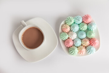 Obraz na płótnie Canvas Multicolored meringues and a cup of coffee on a white background. isolated