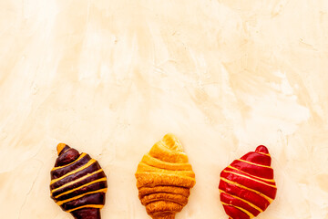 Set of croissants - chocolate, berry, classic - on stone table top view