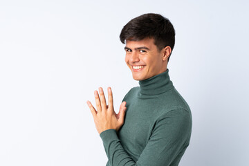 Handsome man over isolated blue background scheming something