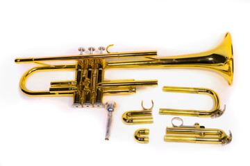 A trumpet's pieces are dismantled and scattered on a white isolated background