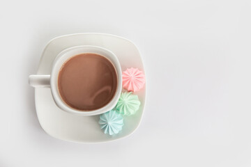 Good morning. meringues and a cup of coffee on a saucer on isolated a white background. Coffee culture concept.
