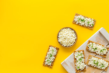 Cottage cheese toast on yellow desk top view copy space