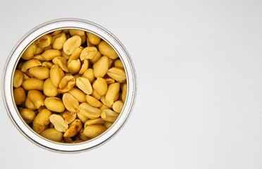 Top view close up of isolated open can with roasted salted peanuts, white background