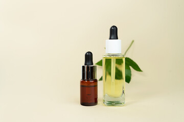 Herbal oil bottles aroma dropper on glass on pastel beige background.