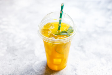 orange juice or lemonade with mint or lemonade with mint  transparent glass cup with mint takeaway drink Menu concept serving size food background top view copy space for text organic healthy eating