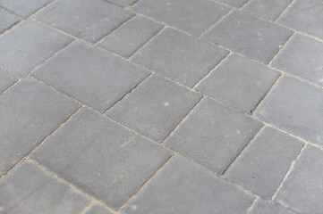 Gray pavement tiles in the street creating a regular grid and texture