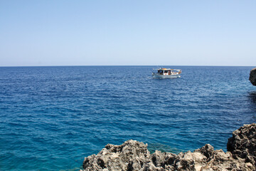 boat in the sea near the rocky shore