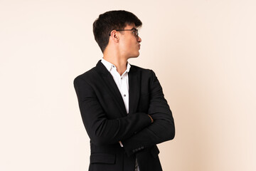 Businessman over isolated beige background laughing