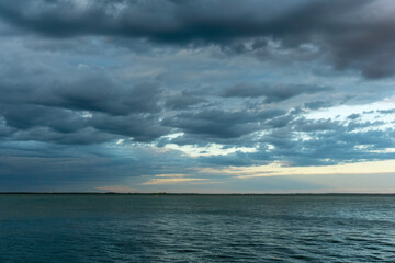 Fototapeta na wymiar Angry clouds over a dark lake