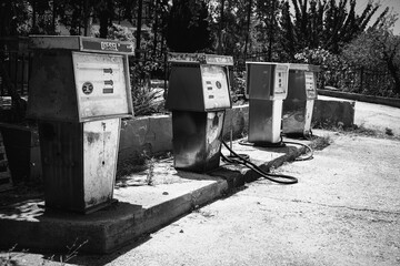 Old, dirty, vintage gas station. Rusty gas pumps. Black and white photo.