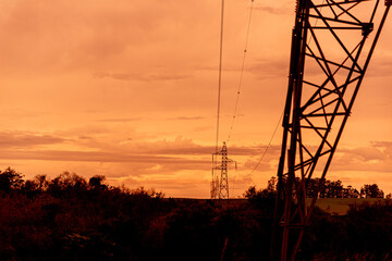 Dramatic reddish sky and the silhuet of power transmission tower in Brazil