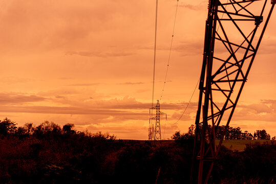 Dramatic reddish sky and the silhuet of power transmission tower in Brazil