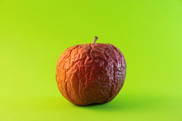 old rotten apple on a colored background close-up