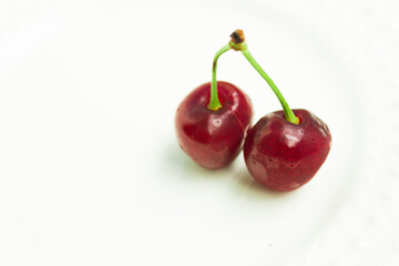 two isolated red ripe and sweet cherries.copy space
