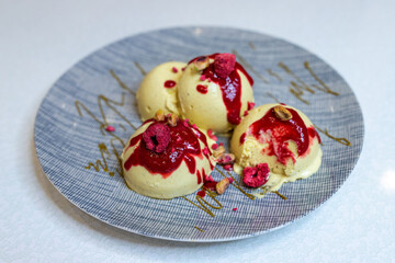 Pistachio ice cream balls with raspberry and berry sauce