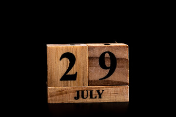 wooden calendar 29 July word on black background with copy space , selective focus at the calendar