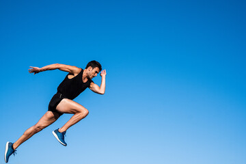 Athlete making a start in front of a blue sky