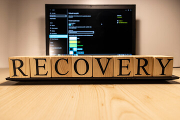 Recovery word from wooden cubes on laptop.