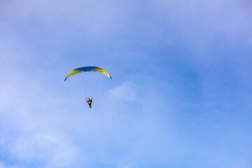 A flying paramotor on a vibrant sky with cloud.