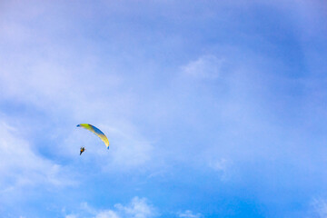 A flying paramotor on a vibrant sky with cloud.