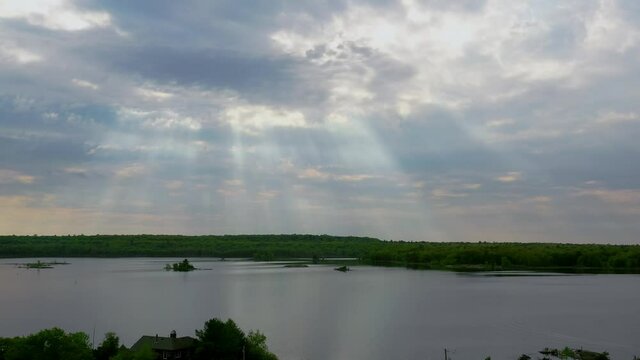 Aerial shot of light rays coming down from a cloudy sky on a summer day