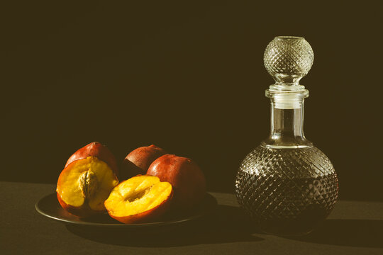 duraznos rojos frescos con una botella de vidrio con licor de cerezas