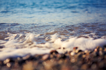 Waves washing over gravel beach, macro shot.