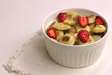 Small grain pancakes with strawberries, fast healthy Breakfast, pancake porridge on a gray background.