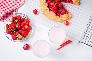Strawberry smoothie milk shake cocktail and strawberry galette. Top view.