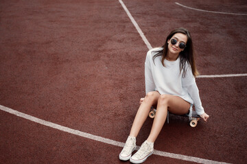 Young Woman With Longboard. Girl skater posing on longboard in sunny weather © glazunoff