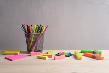 Education concept - pens and sticky note on wooden table