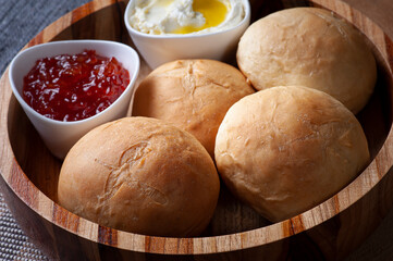 
Homemade bread in a wooden bowl accompanied by curd and jam