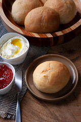 
Homemade bread in a wooden bowl accompanied by curd and jam