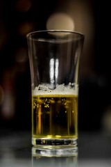 a glass of yellow colored alcoholic beverage / half empty