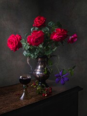Still life with red wine glass and bouquet of red roses